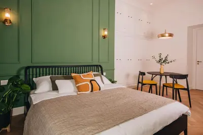 a bedroom with green walls and a bed and a table at Luxury Design Apartment at Old Town Square with Air Condition in Prague