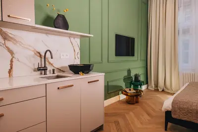 a kitchen with green walls and a sink at Luxury Design Apartment at Old Town Square with Air Condition in Prague