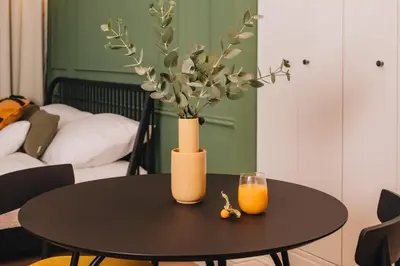 a black table with a vase and a glass of orange juice at Luxury Design Apartment at Old Town Square with Air Condition in Prague