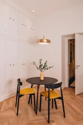 a dining room with a black table and yellow chairs at Luxury Design Apartment at Old Town Square with Air Condition in Prague