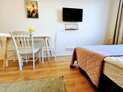 a bedroom with a bed and a table and a television at TERRACE-VIEW PRAGUE APARTMENTS for Business & Leisure, FREE PARKING & Gym, Near Metro & Aqua Sport Centre in Prague