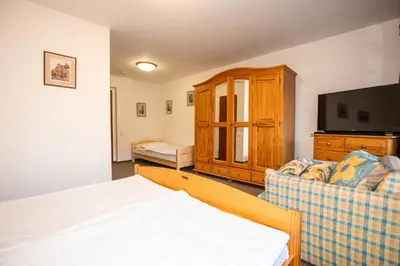 a bedroom with a bed and a tv and a couch at Resort U Jelena in Křivoklát