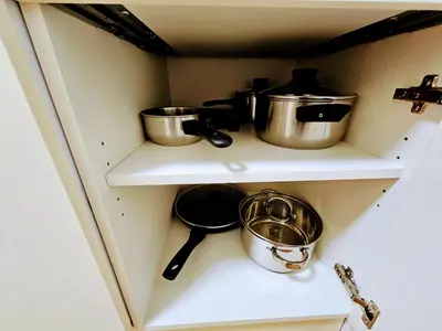 a kitchen with pots and pans on a shelf at TERRACE-VIEW 2BR PRAGUE APARTMENTS for Business & Leisure, FREE PARKING & Gym, Near Metro & Aqua Sport Centre in Prague
