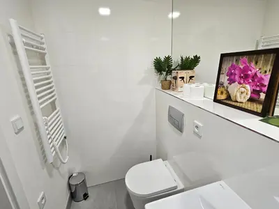 a white bathroom with a toilet and a mirror at TERRACE-VIEW 2BR PRAGUE APARTMENTS for Business & Leisure, FREE PARKING & Gym, Near Metro & Aqua Sport Centre in Prague