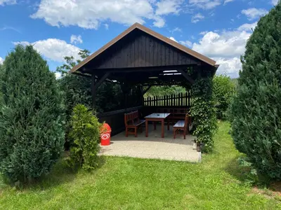 a gazebo with a table and chairs in a garden at Apartmány Kamejk in Kamýk nad Vltavou