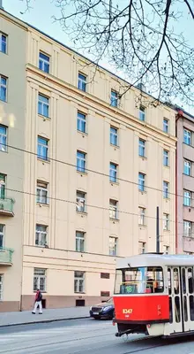 a red tram on a street in front of a building at Vintage Brussels Style on Prague 4 in Prague