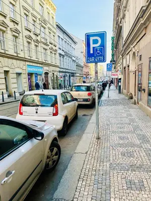 a parking sign on the side of a street with parked cars at Retro style in centrum Prague Andel in Prague