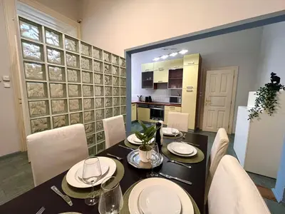 a dining room with a table and chairs and a kitchen at Spacious 4BR Apartment by Charles Bridge in Prague