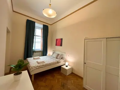 a small bedroom with a bed and a window at Spacious 4BR Apartment by Charles Bridge in Prague