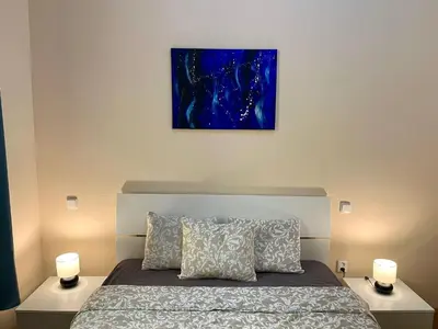 a bedroom with a bed with two lamps and a painting at Spacious 4BR Apartment by Charles Bridge in Prague