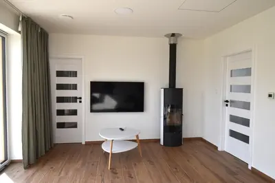 a living room with a white table and a tv at Chata U Bezedné in Velký Osek