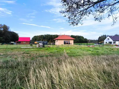 a house with a red roof in a field at Chata U Bezedné in Velký Osek