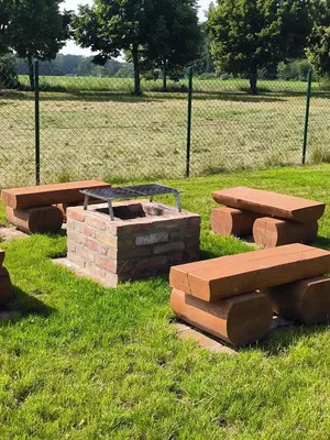 a group of picnic tables and benches in a field at Chata U Bezedné in Velký Osek