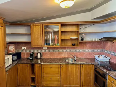 a kitchen with wooden cabinets and a sink at Comfortable 3 Bedroom apartment in the Heart of Prague in Prague
