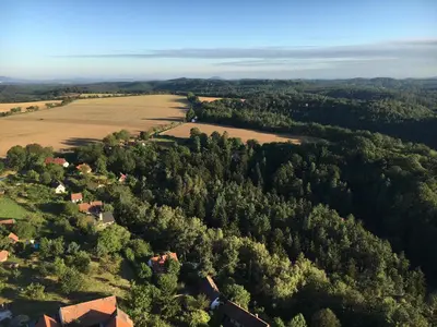 an aerial view of a farm with trees and a field at Nostalgická myš in Kokořín