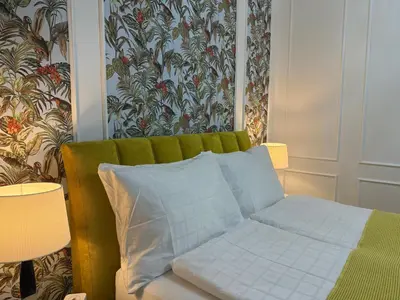 a bedroom with a bed with a green head board at Momoko in Prague
