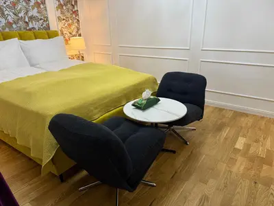 a bedroom with a bed and two chairs and a table at Momoko in Prague