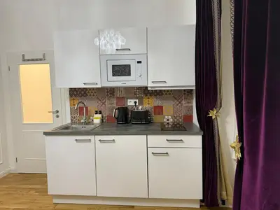 a kitchen with white cabinets and a microwave at Momoko in Prague