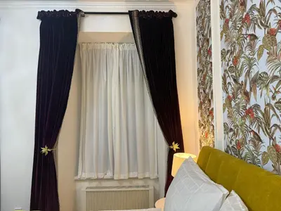 a room with a window with curtains and a radiator at Momoko in Prague