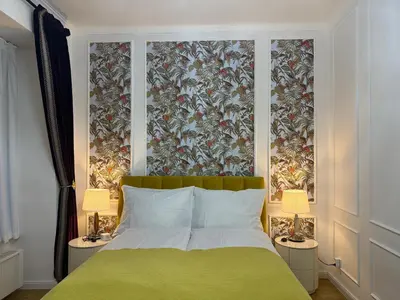 a bedroom with a green bed with two lamps at Momoko in Prague