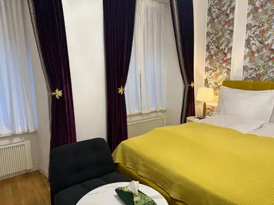 a hotel room with a yellow bed and a chair at Momoko in Prague