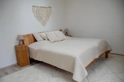 a bedroom with a bed with white sheets and pillows at Charming studio near Prague Airport in Tuchoměřice