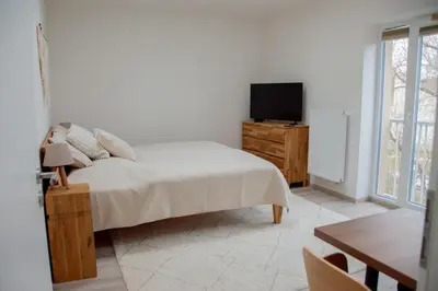 a bedroom with a bed and a tv on a dresser at Charming studio near Prague Airport in Tuchoměřice