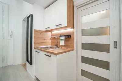a kitchen with white cabinets and a sink at Sights at Your Doorstep in Prague