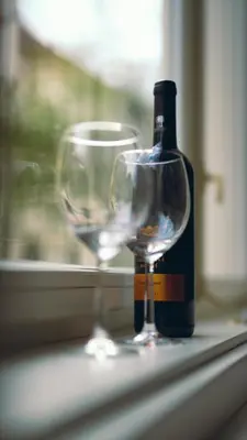 a bottle of wine and a wine glass on a window sill at Chic Brick Suites in Historic Prague City Center by Rentez in Prague