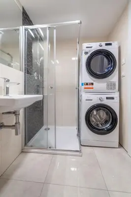 a washer and dryer in a bathroom with a sink at Chic Brick Suites in Historic Prague City Center by Rentez in Prague
