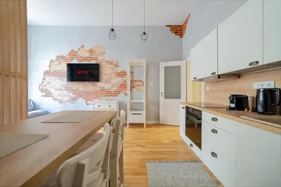 a kitchen with a table and a brick wall at Chic Brick Suites in Historic Prague City Center by Rentez in Prague