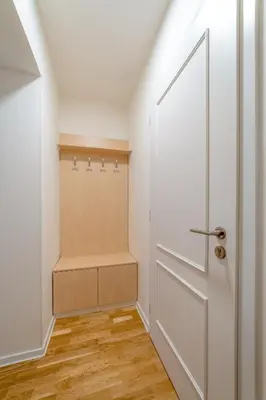 a small closet with a white door and wooden floors at Chic Brick Suites in Historic Prague City Center by Rentez in Prague