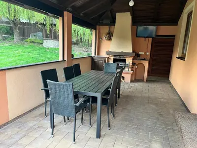 a table and chairs on a patio with a stove at Ubytování v Nalžovicích in Nalžovice