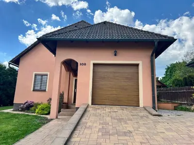 a pink house with a garage at Ubytování v Nalžovicích in Nalžovice