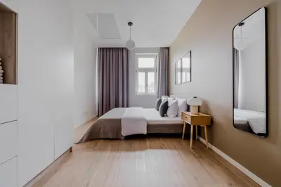 a white bedroom with a bed and a mirror at Blueground Vinohrady close to Namesti Miru PRG-2 in Prague