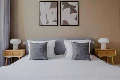 a bedroom with a white bed with two night stands at Blueground Vinohrady close to Namesti Miru PRG-2 in Prague