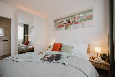 a bedroom with a bed with a book on it at Prague Days - Two-Bedroom Apartment with Workspace and 200Mbps WiFi in Prague