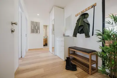 a hallway with white walls and wooden floors and a bench at Prague Days - Two-Bedroom Apartment with Workspace and 200Mbps WiFi in Prague