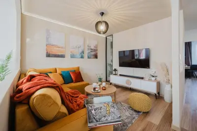a living room with a couch and a tv at Prague Days - Two-Bedroom Apartment with Workspace and 200Mbps WiFi in Prague