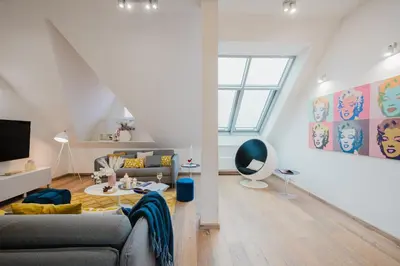 a living room with a couch and a table at Prague Days - Three-bedroom Loft with Fireplace in Pop-art Style in Prague