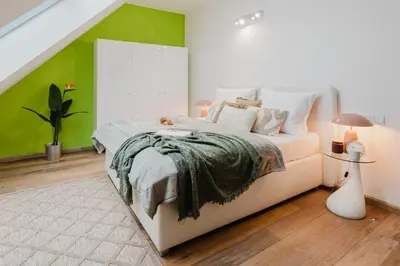 a bedroom with a bed with a green accent wall at Prague Days - Three-bedroom Loft with Fireplace in Pop-art Style in Prague
