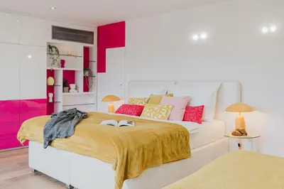 a bedroom with a large white bed with red accents at Prague Days - Three-bedroom Loft with Fireplace in Pop-art Style in Prague