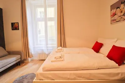 a white bed with red pillows in a room at Spacious apartment in the center of Prague in Prague