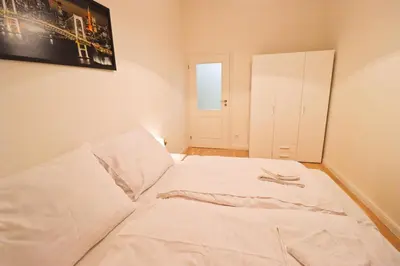 a white bed in a room with a picture on the wall at Spacious apartment in the center of Prague in Prague