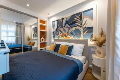a bedroom with a blue bed and a large mirror at Design Apartments close to Wenceslas Square with AC in Prague