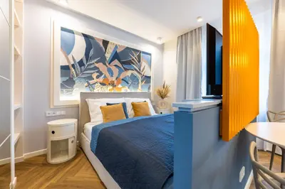 a bedroom with a blue bed and a tv at Design Apartments close to Wenceslas Square with AC in Prague