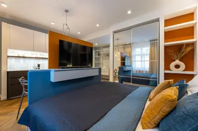 a bedroom with a large blue bed and a flat screen tv at Design Apartments close to Wenceslas Square with AC in Prague