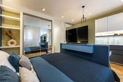 a bedroom with a large blue bed and a tv at Design Apartments close to Wenceslas Square with AC in Prague