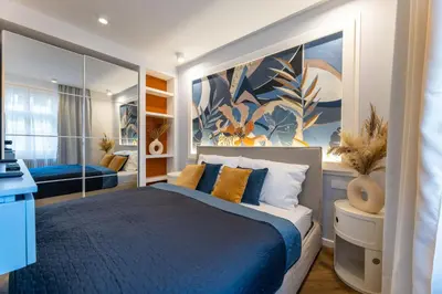 a bedroom with a blue bed and a large painting at Design Apartments close to Wenceslas Square with AC in Prague