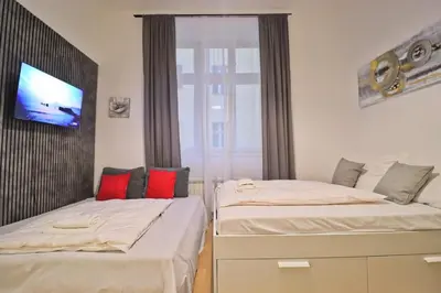 two beds in a room with a tv on the wall at Modern apartment in the heart of Prague in Prague